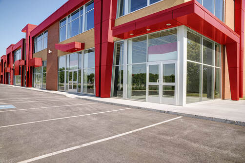 Picture of a red and tan business building with tint on the windows