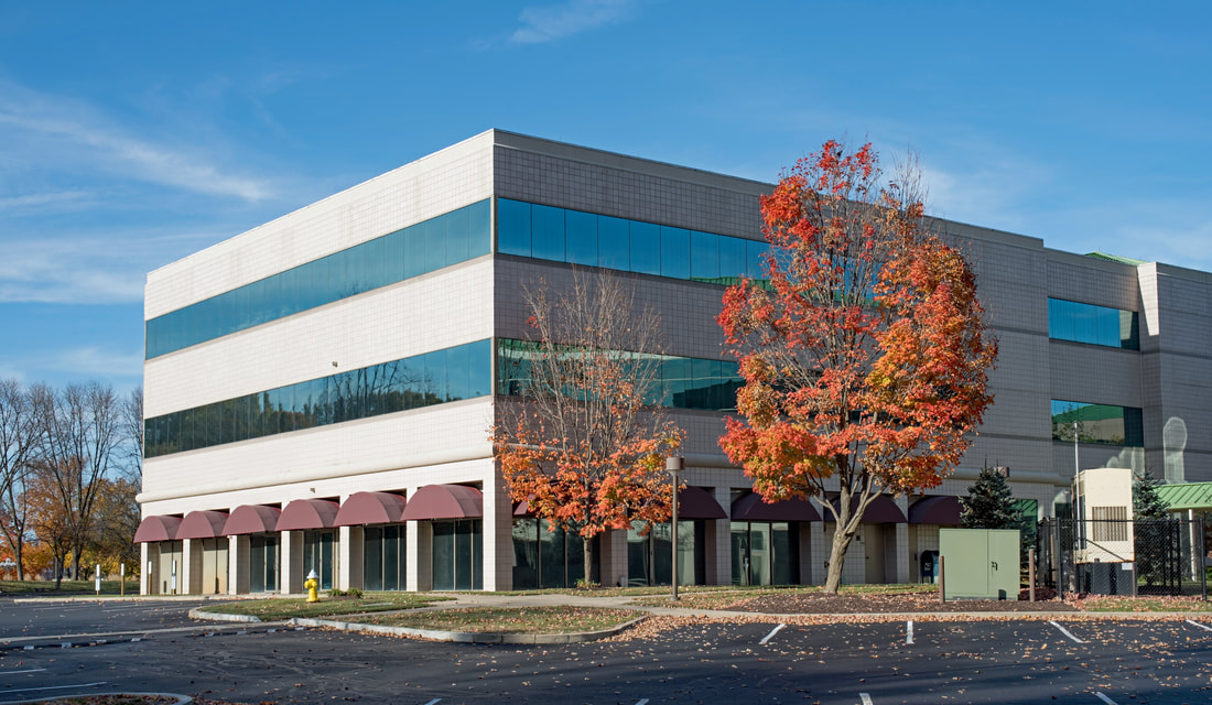 Picture of commercial business building with a parking lot in front of it